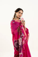 Woman wearing a vibrant pink saree with intricate patterns on a white background