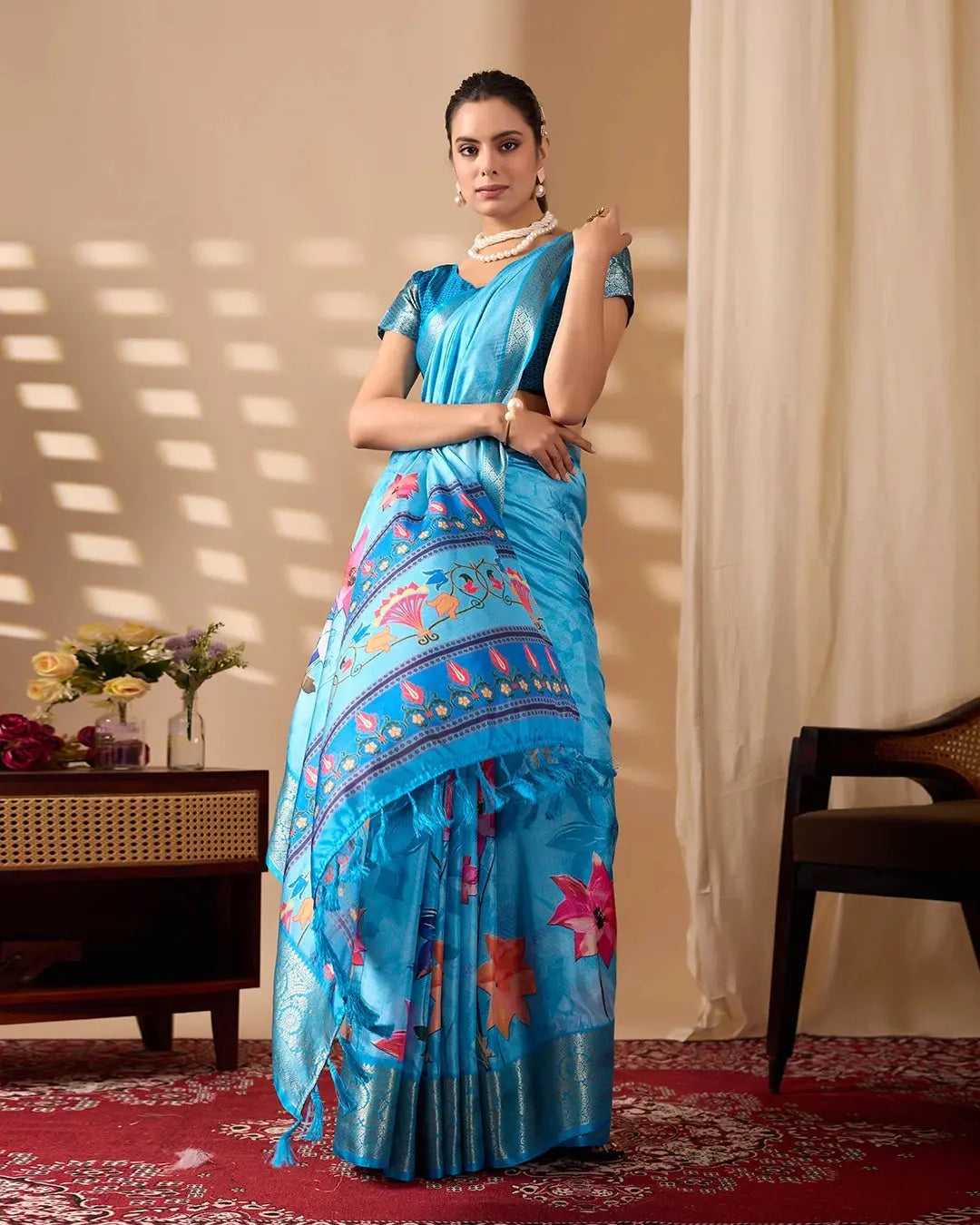 Beautiful Blue Printed Saree featuring colorful floral motifs, woven border, matching blouse, and decorative tassels
