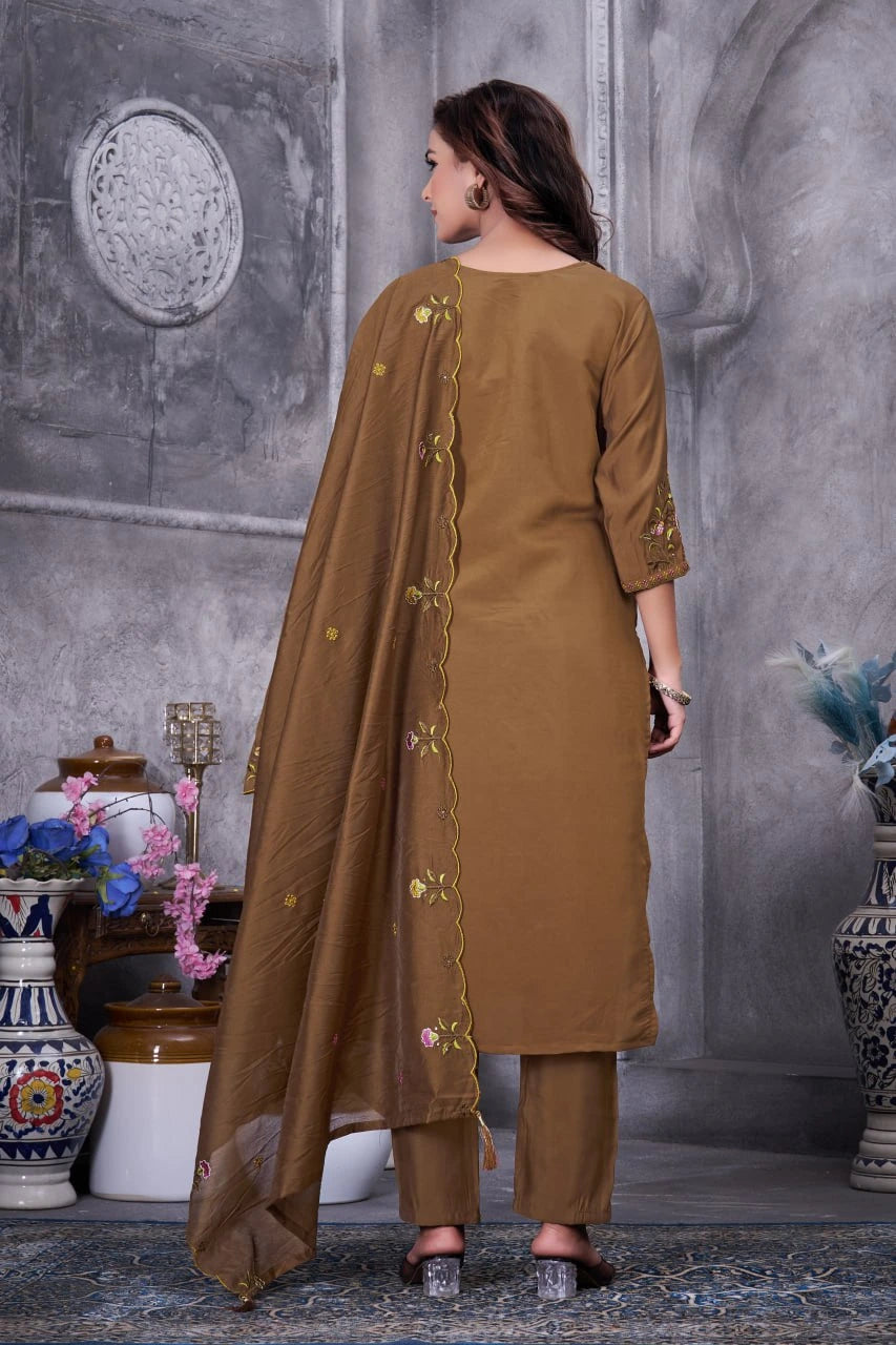 Woman wearing a brown traditional outfit with a long dupatta in an indoor setting.