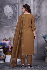 Woman wearing a brown traditional outfit with a long dupatta in an indoor setting.