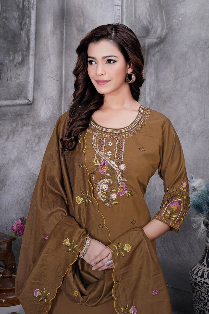 Woman wearing a brown embroidered outfit against a gray background