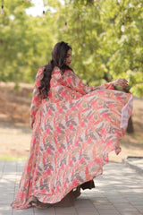 Woman in a floral dress standing outdoors with greenery in the background