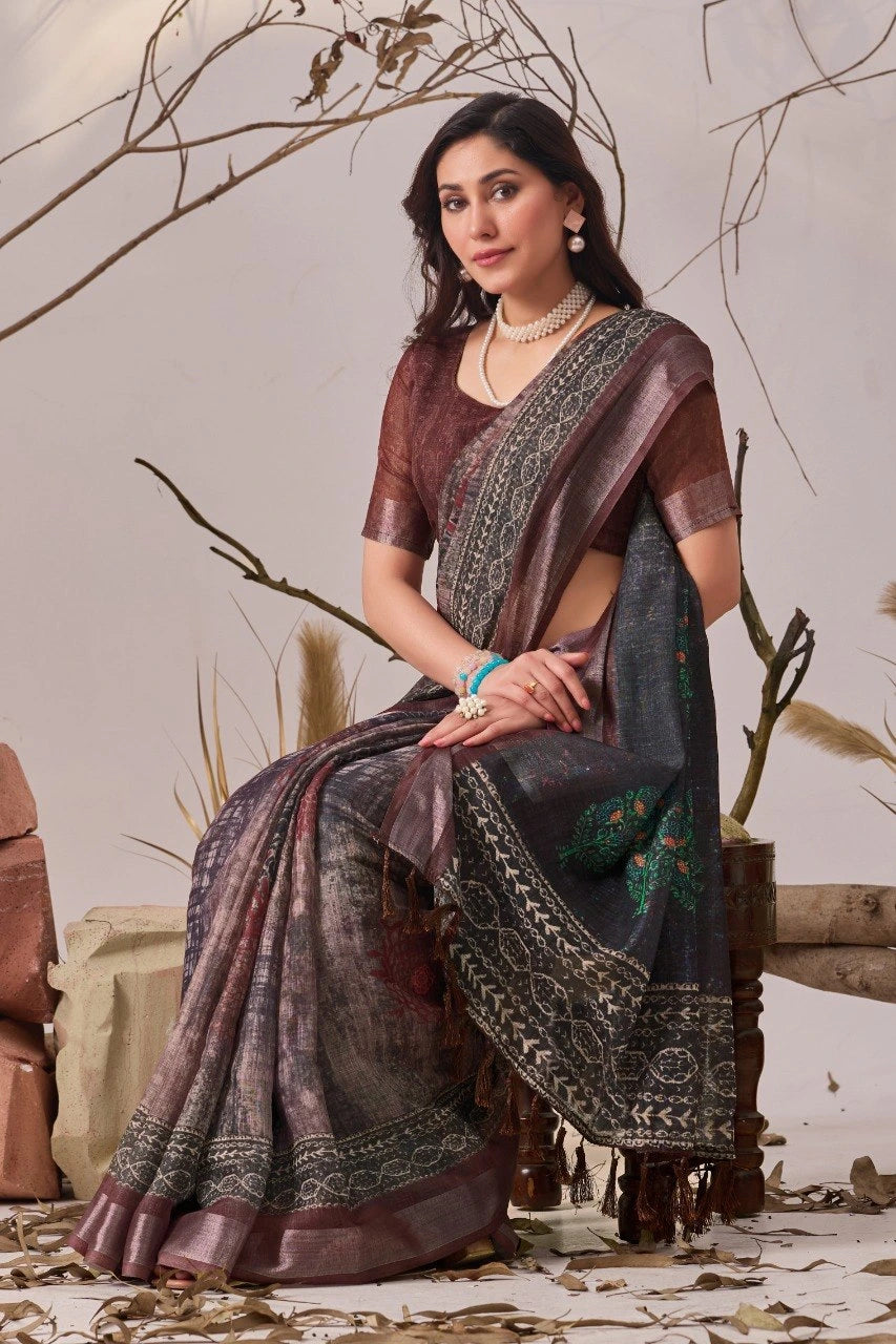 Woman in a traditional saree sitting in a decorative setting with branches and stones.