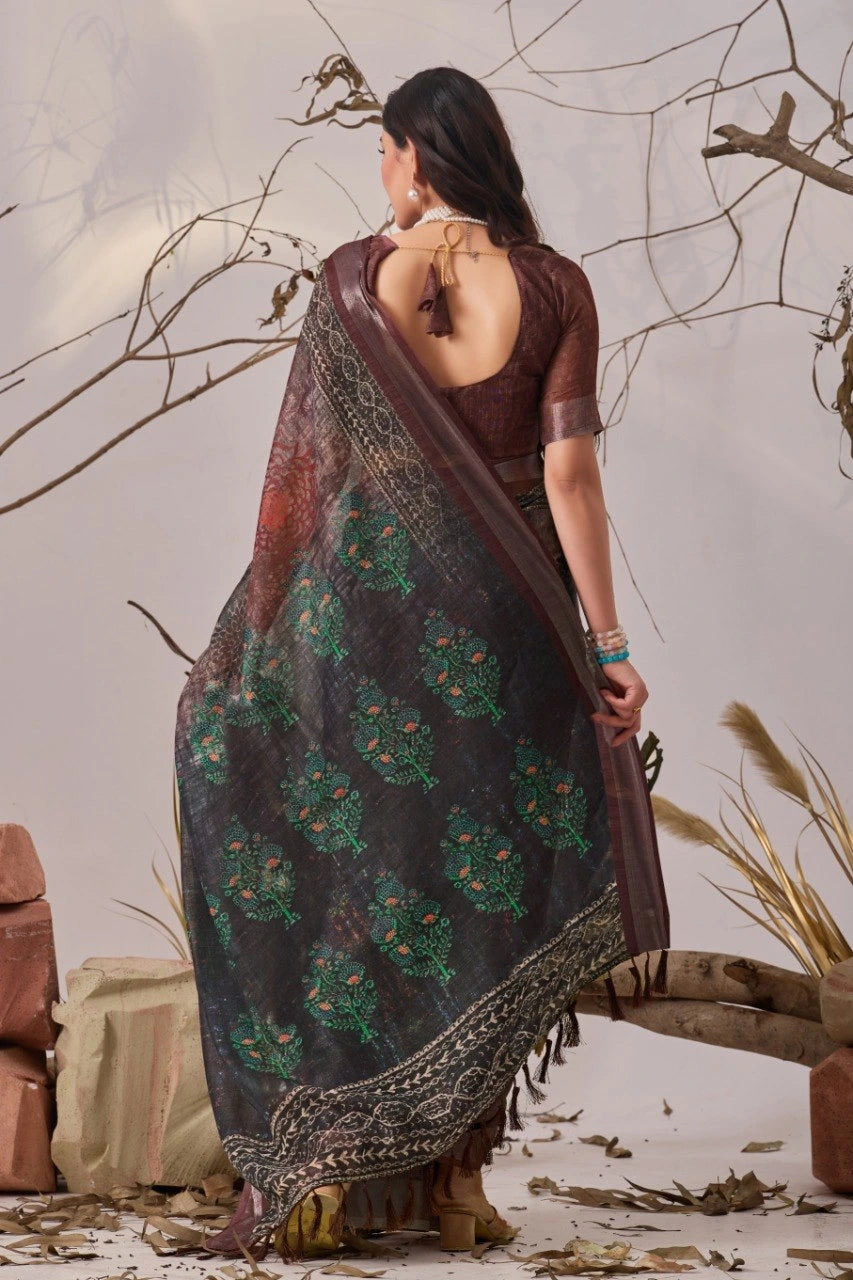 Woman wearing a dark saree with floral patterns in a natural setting