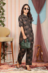 Woman in a patterned outfit holding a green handbag in an indoor setting.