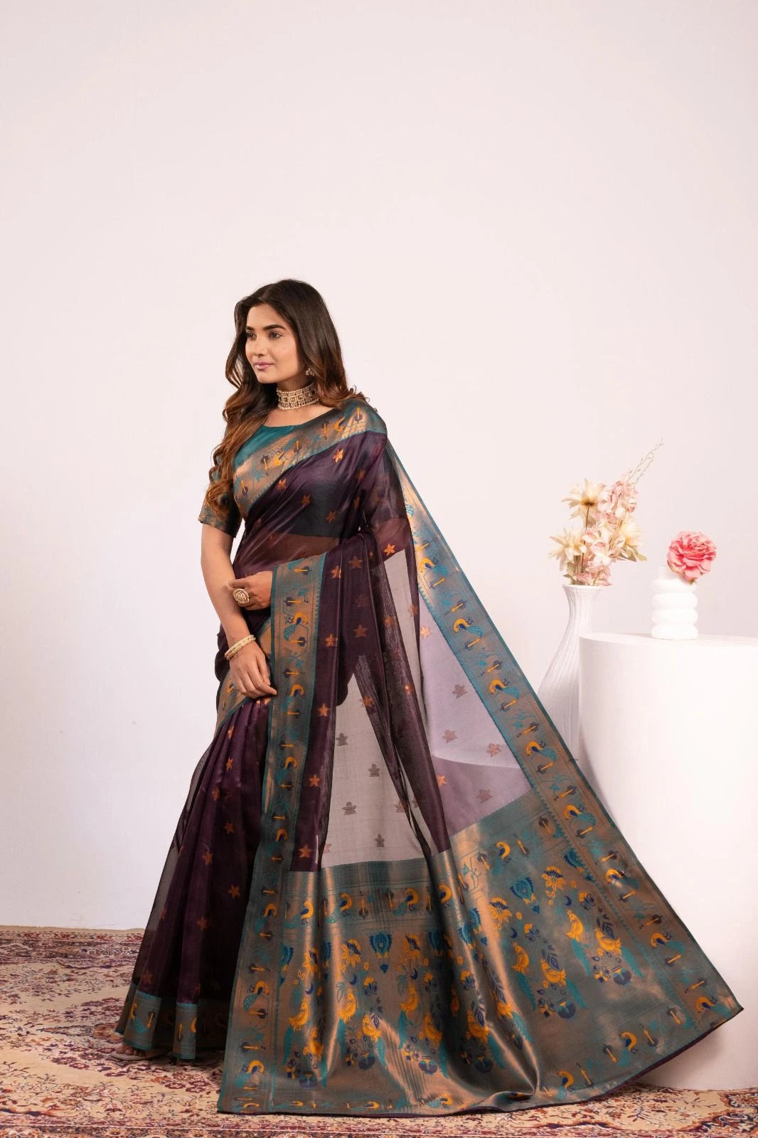 Woman wearing a traditional saree with a floral background