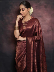Woman wearing a maroon saree with a gold border against a dark background