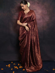 Woman wearing a maroon saree with a dark background