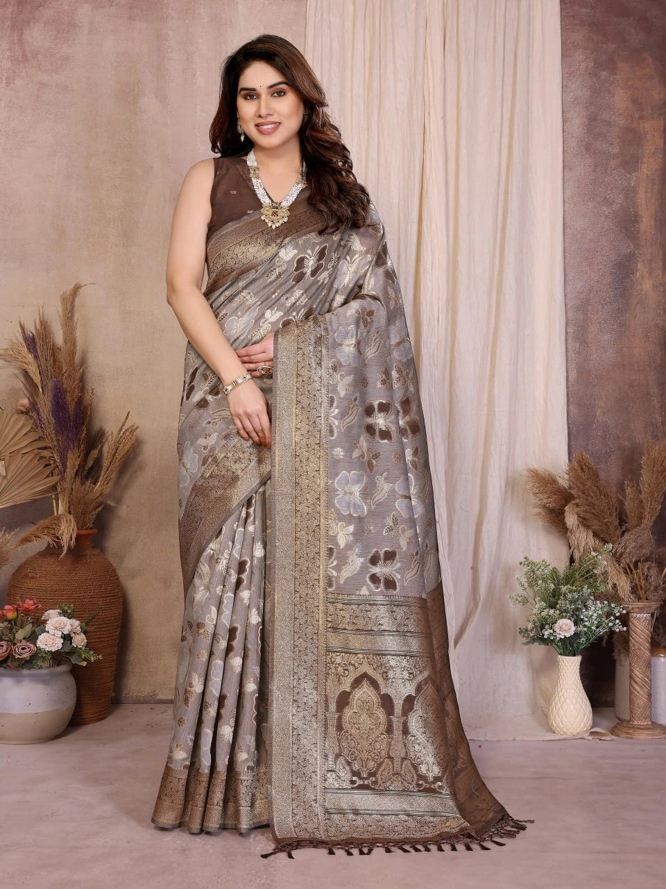Woman wearing a saree with a floral pattern in a decorated indoor setting