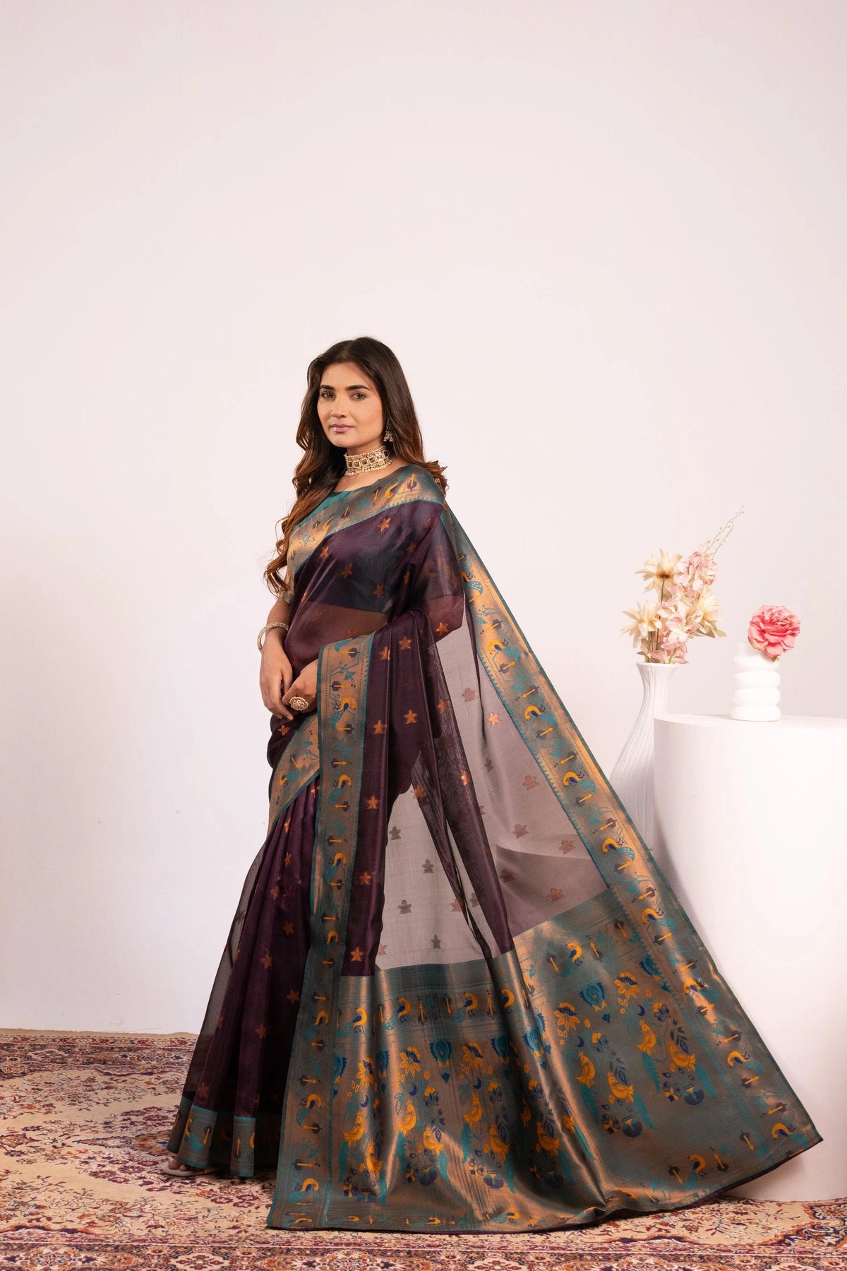 Woman wearing a traditional saree with a floral background
