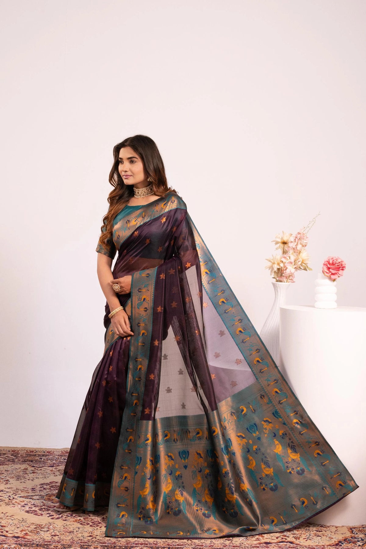 Woman wearing a traditional saree with a floral background
