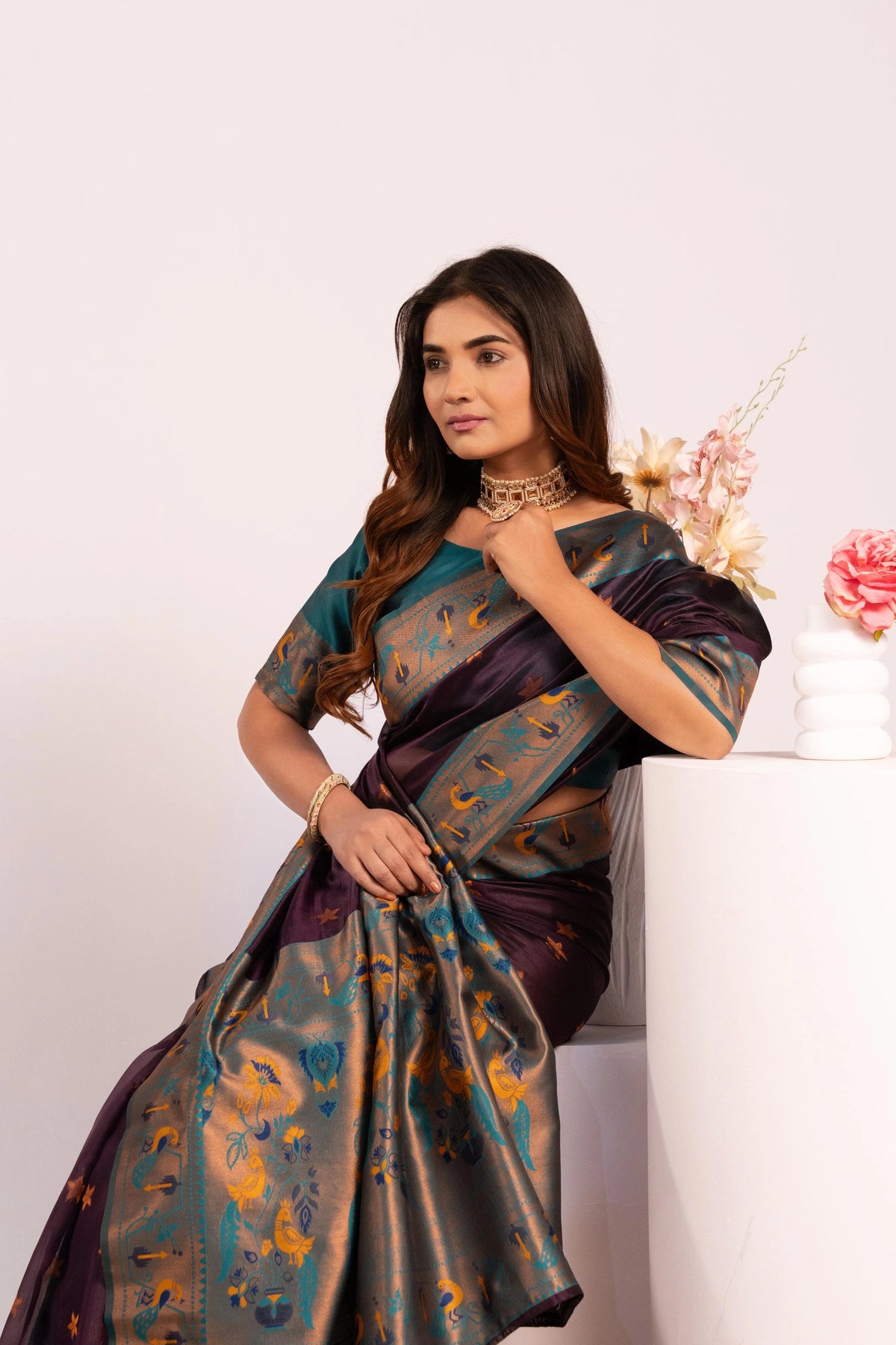 Woman wearing a traditional saree with a floral background