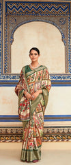Woman in a traditional saree standing in front of an ornate wall.