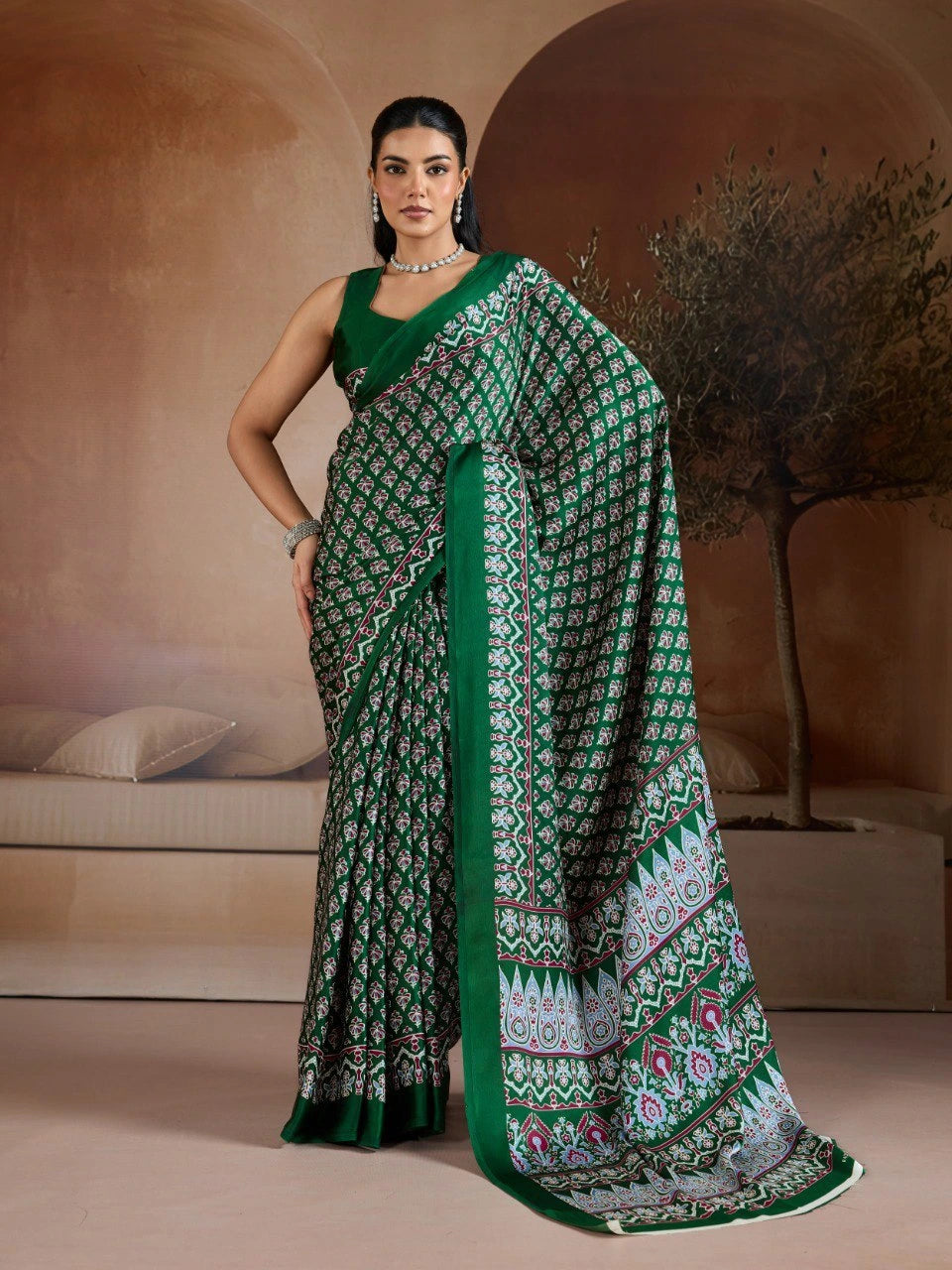 Woman wearing a green and white patterned saree in an indoor setting.