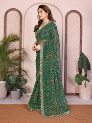 Woman wearing a green saree with a pattern in a decorated room with plants.
