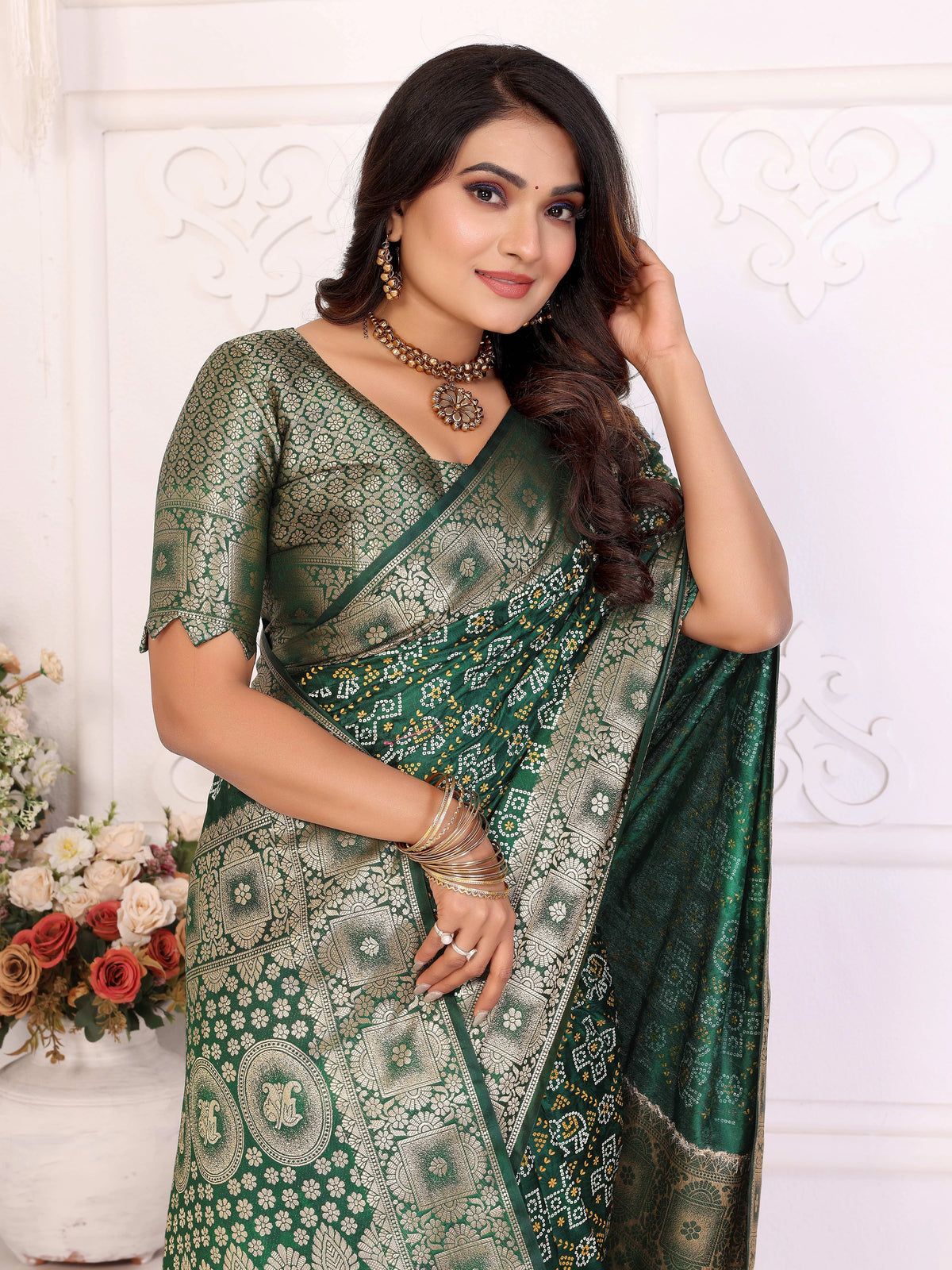 Woman wearing a green saree with a white floral background
