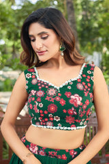 Woman wearing a green floral top with a blurred natural background