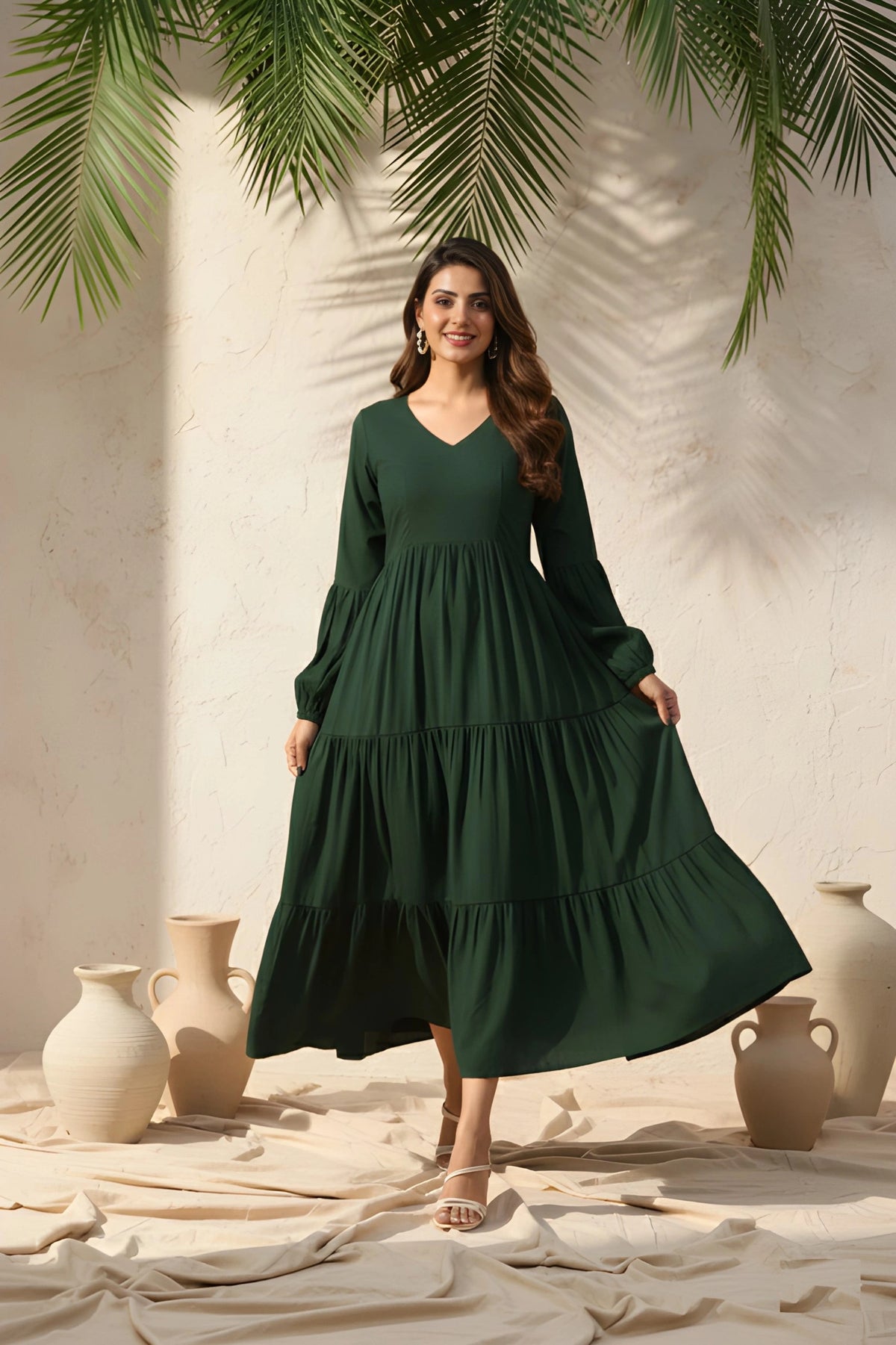 Woman wearing a green dress standing in a sunlit room with decorative vases and plants.