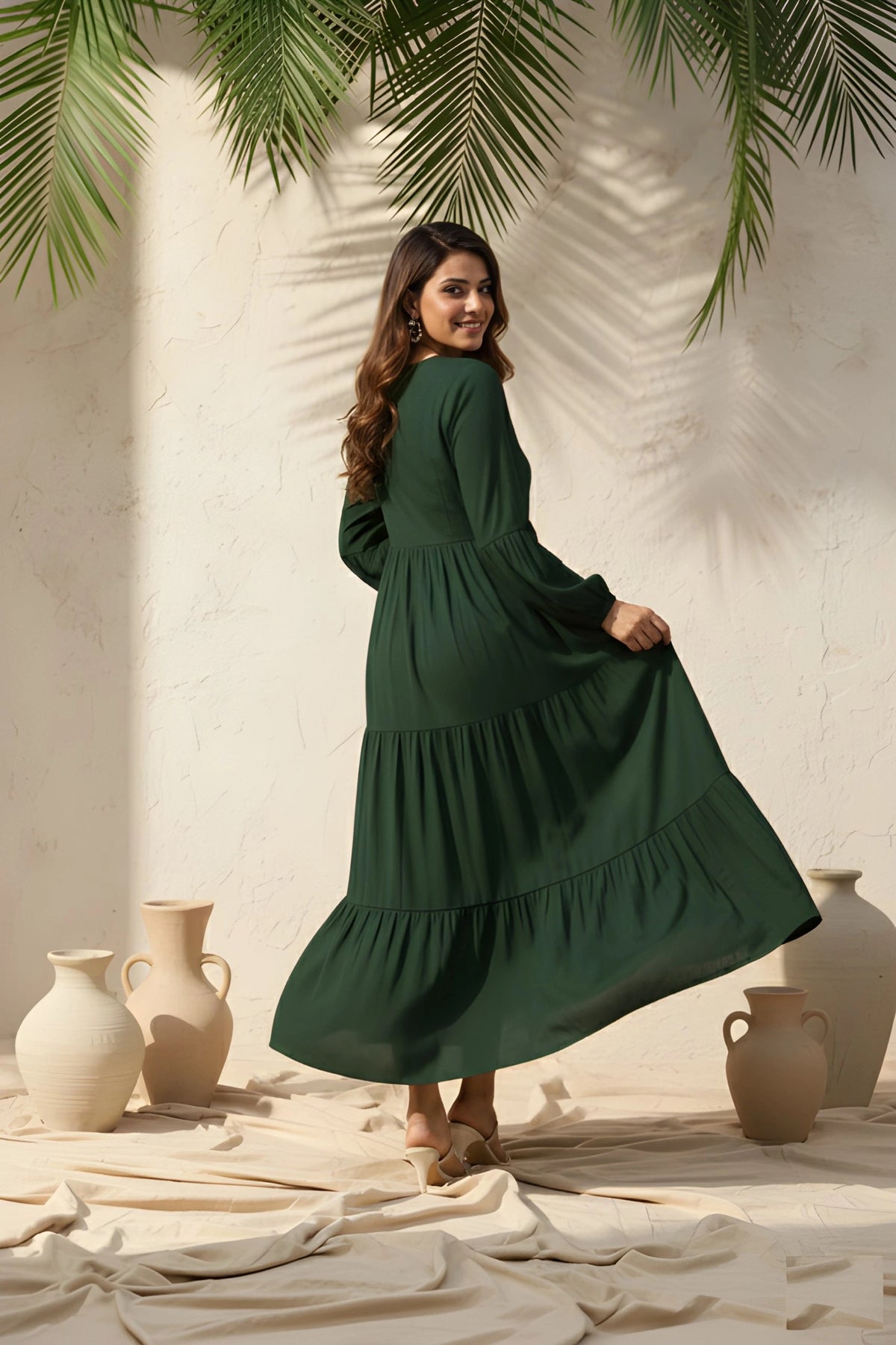 Woman in a green dress standing in a sunlit room with vases and plants.