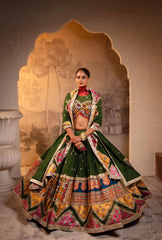 Woman in a traditional green and multicolored outfit standing in front of an archway.