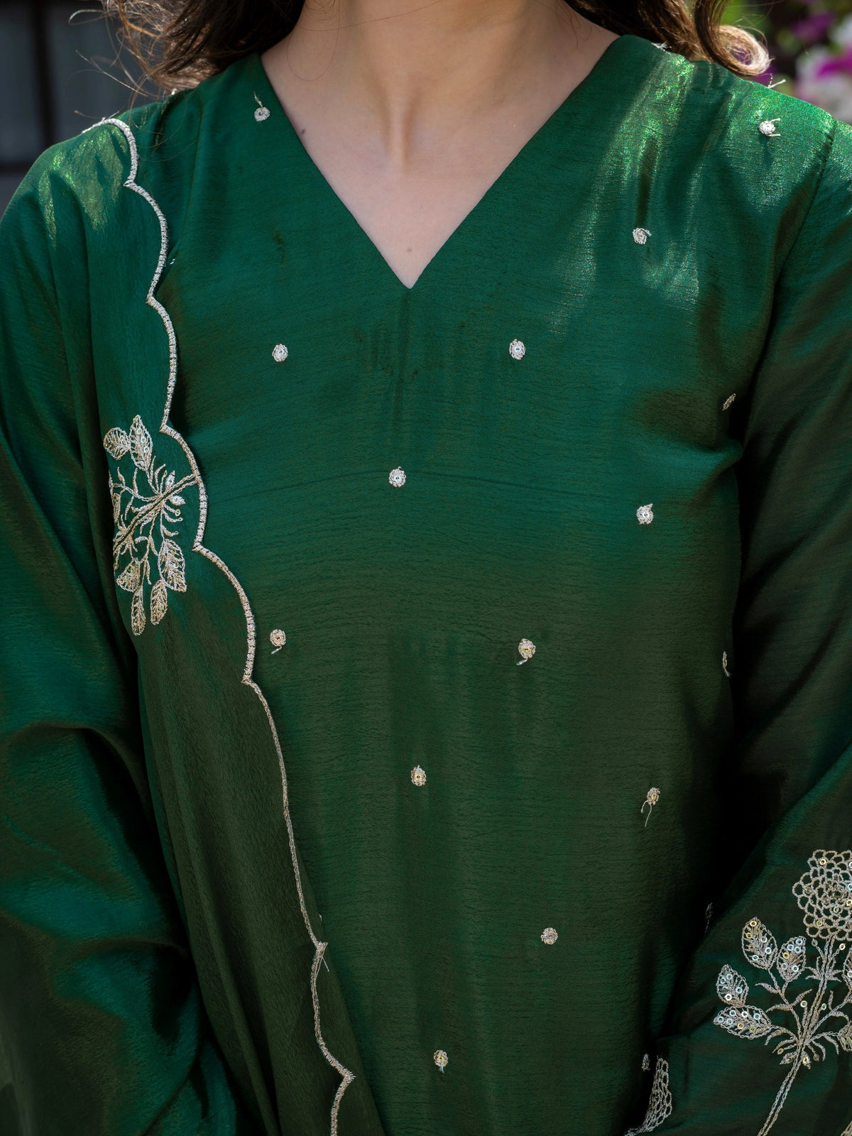 Green dress with white embroidery on a blurred background
