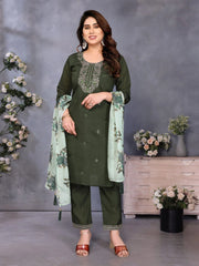 Woman in green traditional outfit with floral dupatta against a gray background