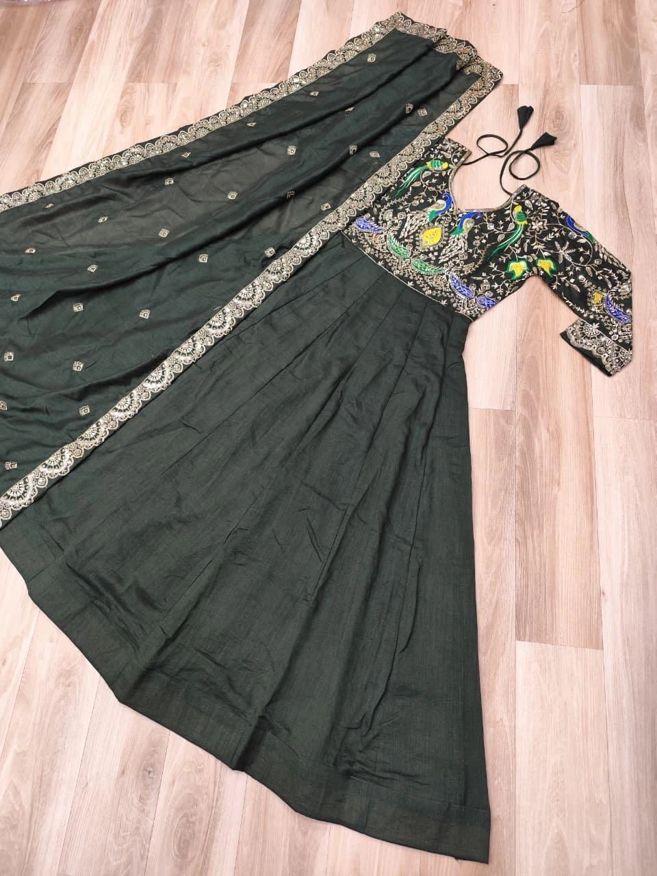 Dark green saree with embroidered blouse on a wooden floor