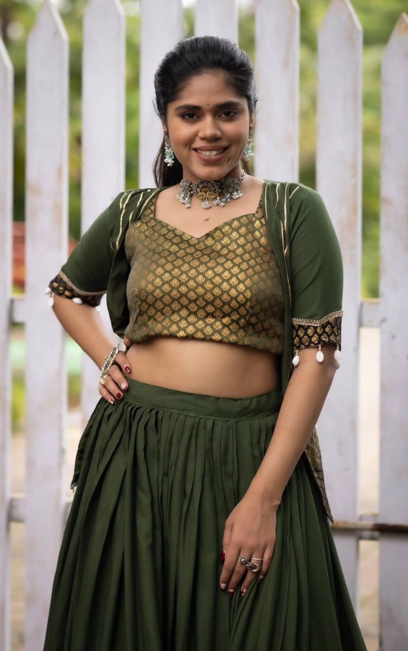 Woman wearing a green traditional outfit with a white picket fence background