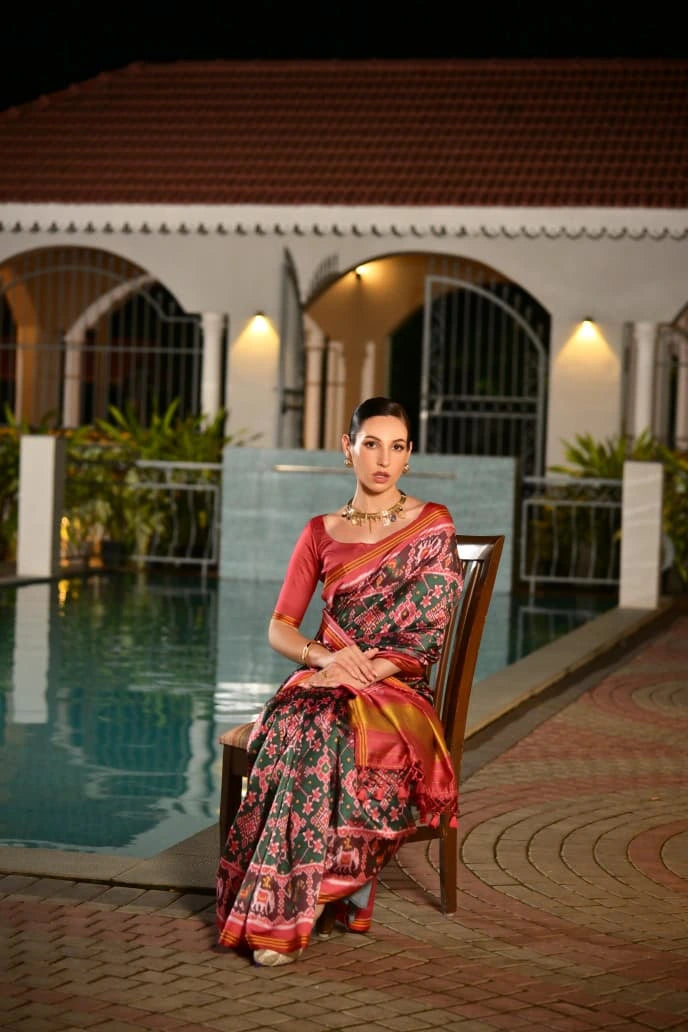 Traditional Indian silk saree in dark green with intricate Ikkat patterns showcased online
