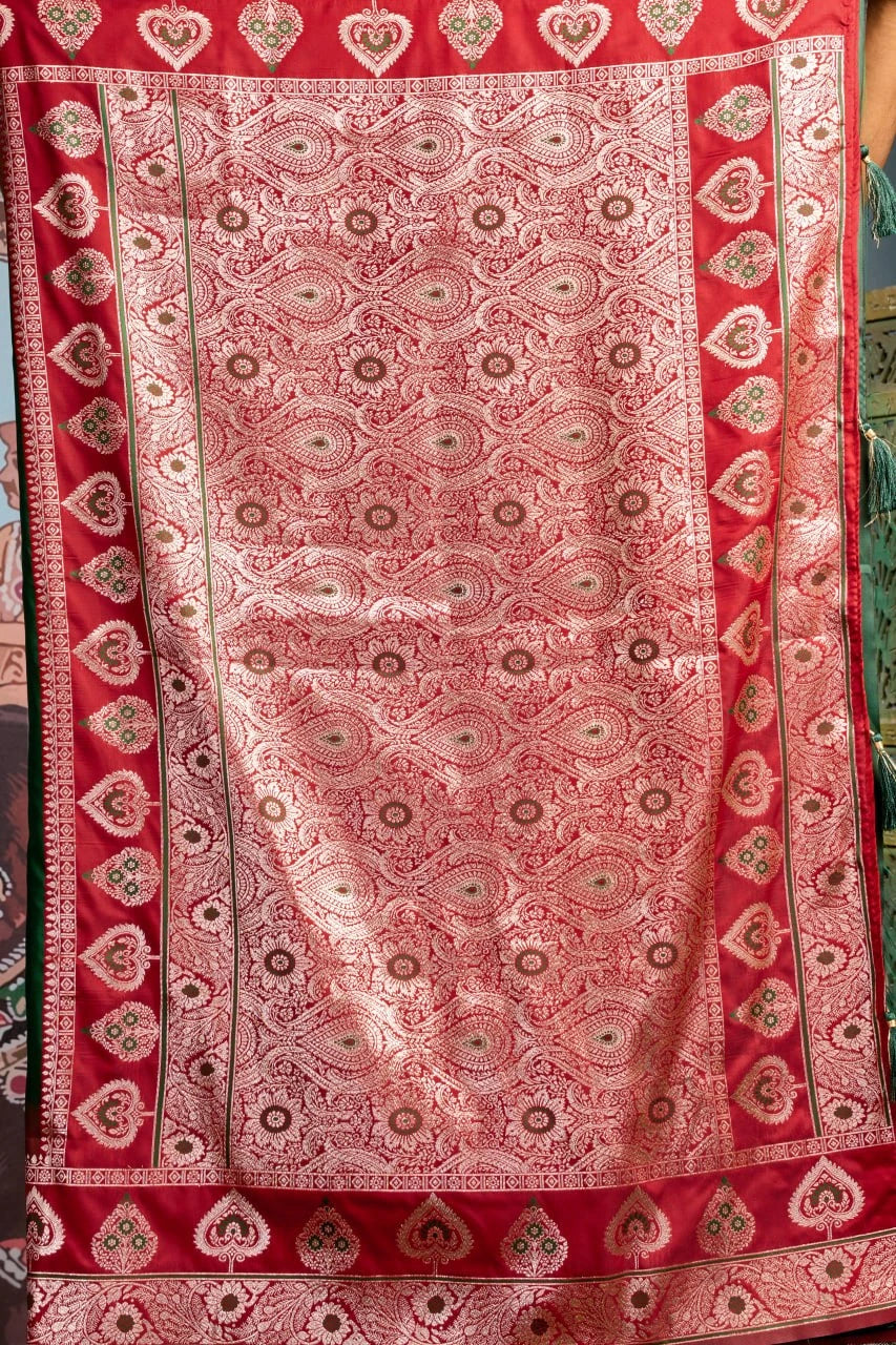 Red patterned fabric with intricate designs on a plain background
