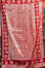 Red patterned fabric with intricate designs on a plain background