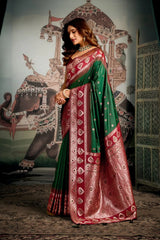 Woman in a traditional saree standing in front of an ornate wall.