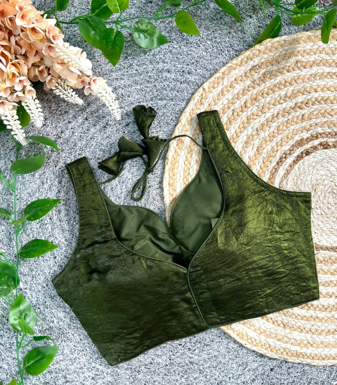 Green crop top on a textured surface with floral and leaf decorations