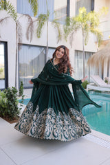 Woman in a green and white dress standing by a pool with a modern building in the background