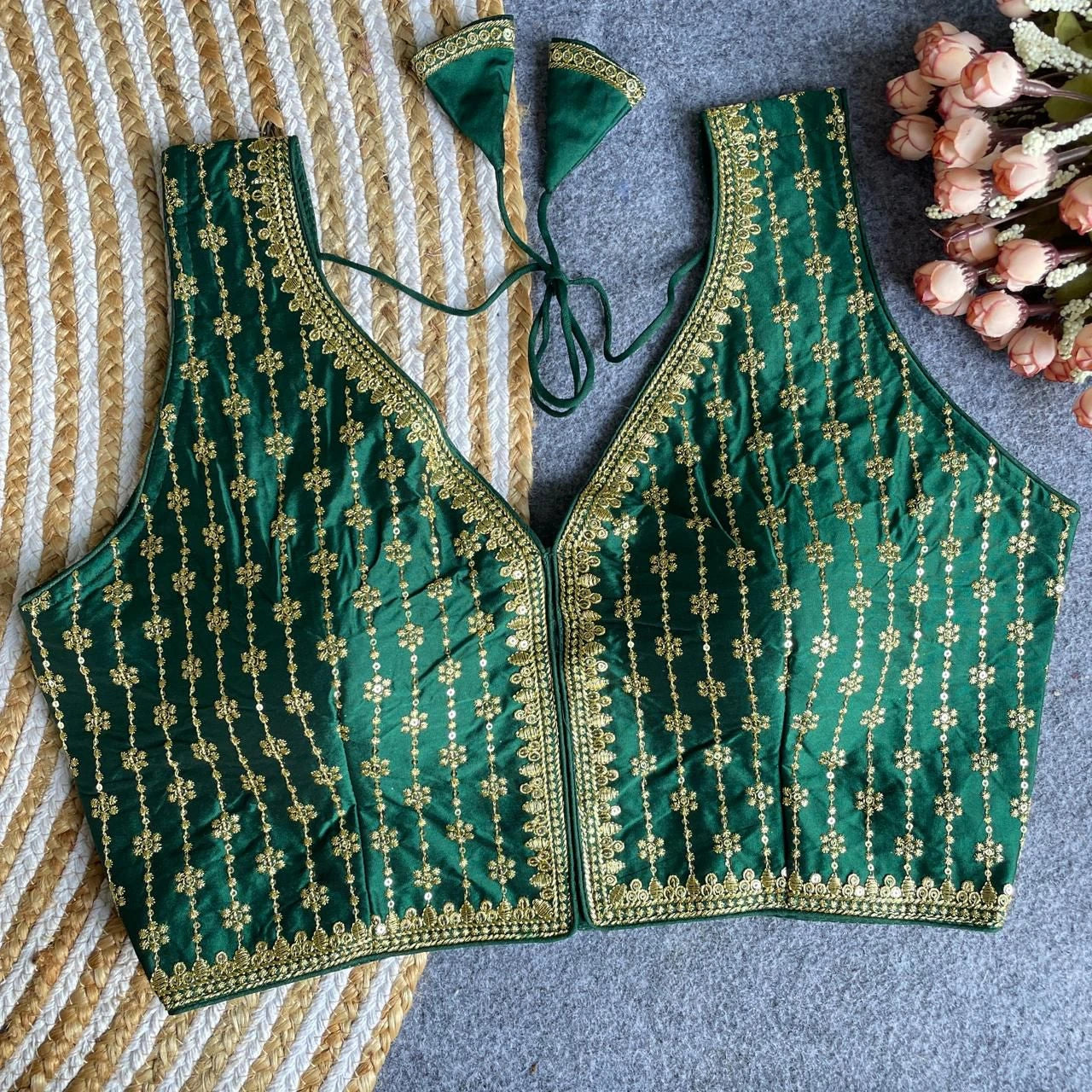 Green embroidered blouse on a striped fabric background