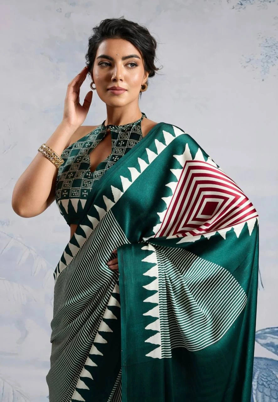 Woman wearing a green saree with geometric patterns against a light gray background