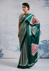 Woman wearing a green and gray patterned saree with a white background