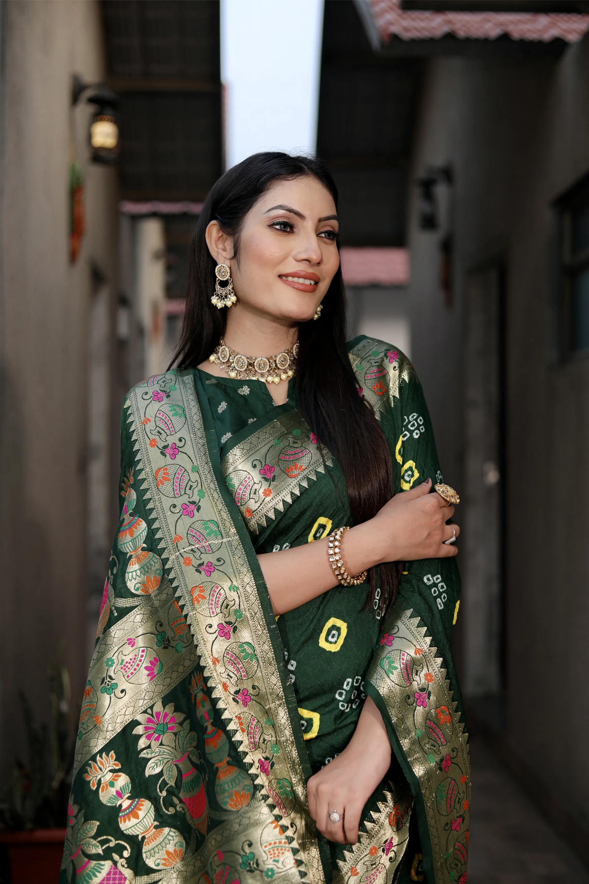 Woman wearing a traditional green embroidered saree with a blurred background