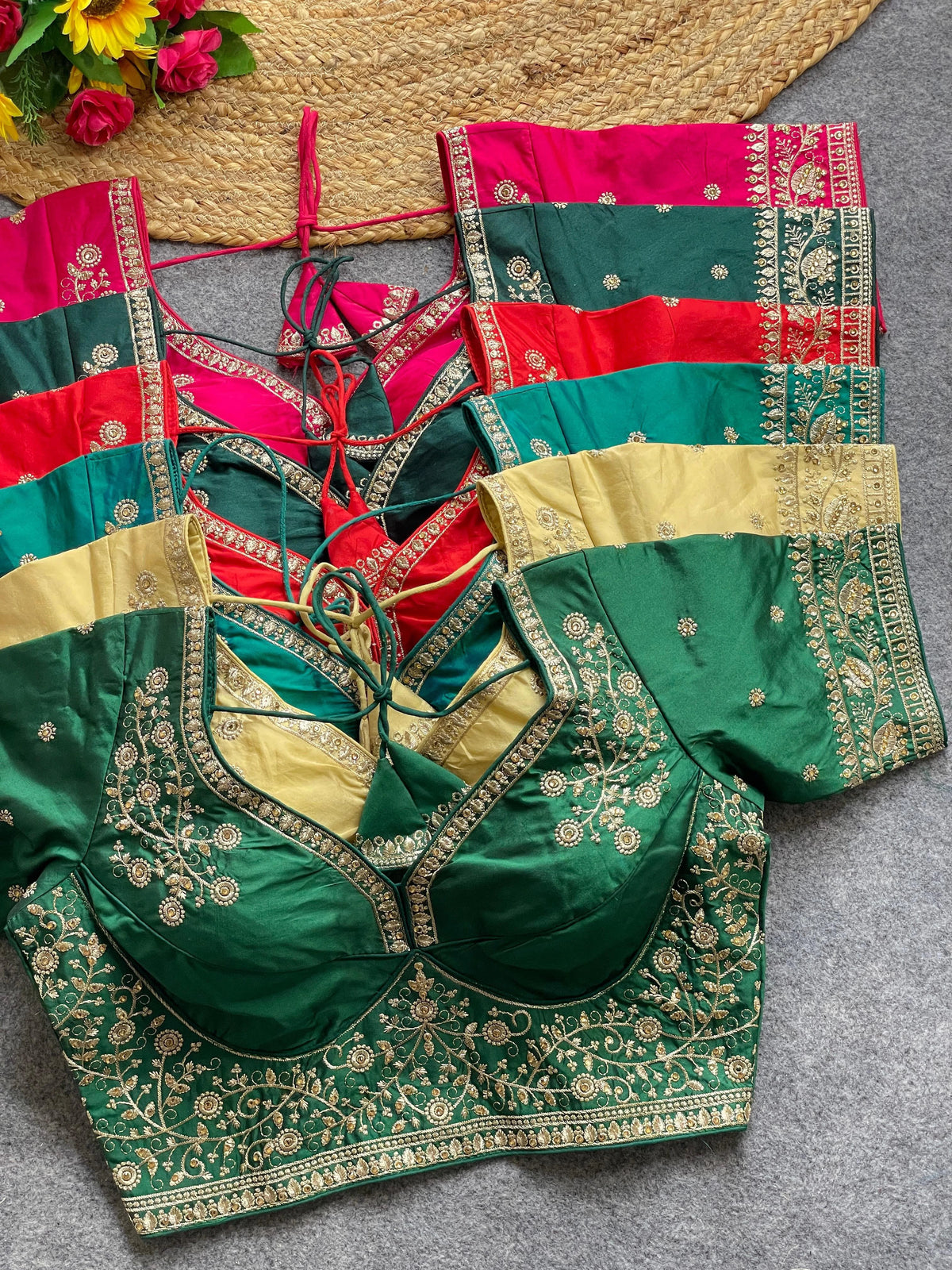 Green embroidered blouse with red and gold accents on a gray surface
