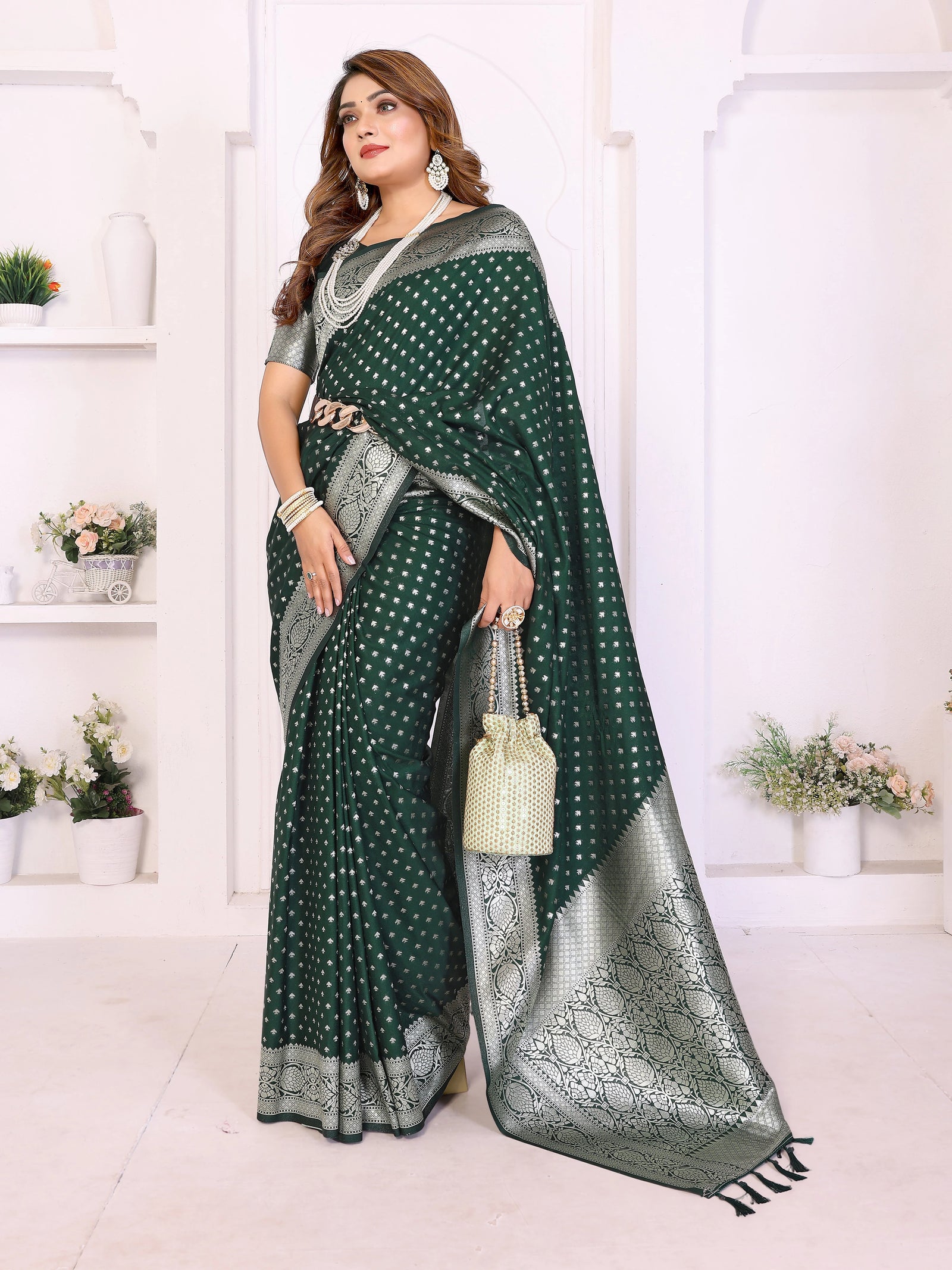 Woman wearing a green and silver saree with a white background