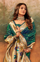 Woman wearing a traditional green and gold saree with a textured wall background