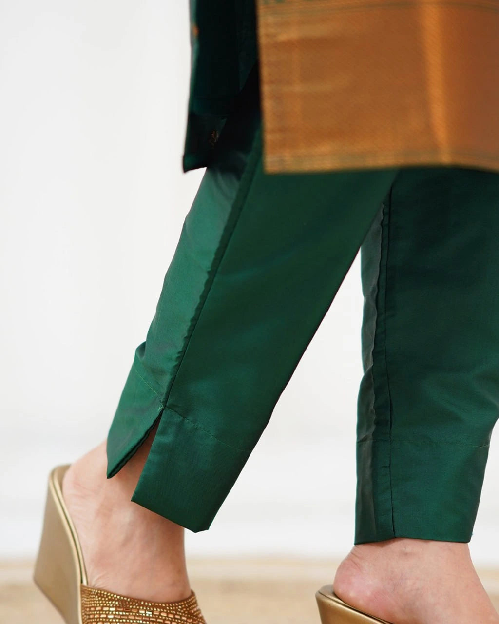 Green pants worn by a person with a blurred background