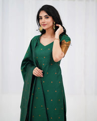 Woman wearing a green saree with gold patterns against a white background