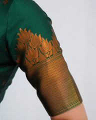 Close-up of a green garment with intricate gold embroidery on a white background
