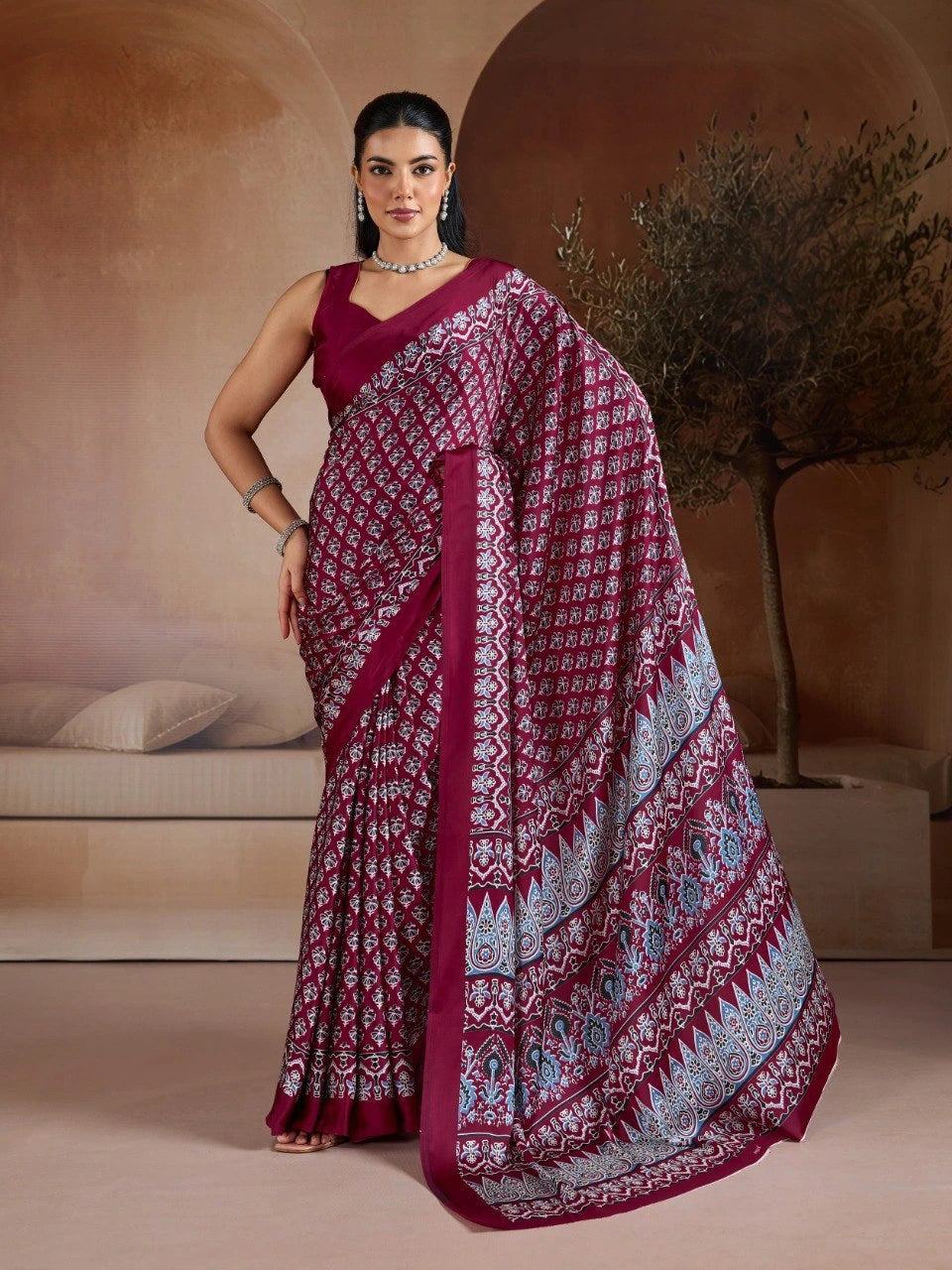 Woman wearing a maroon saree with white patterns in an indoor setting
