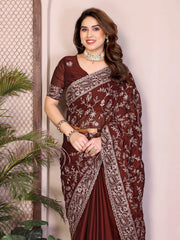 Woman wearing a maroon saree with white patterns against a neutral background