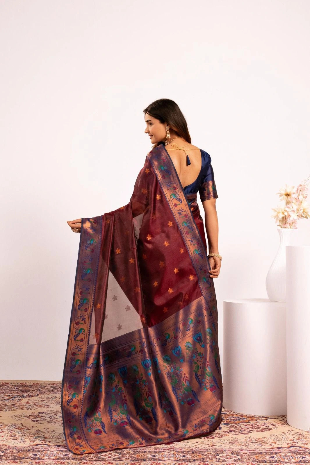 Woman wearing a traditional saree with a floral pattern on a white background