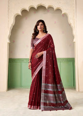 Woman wearing a maroon saree with a green and beige background