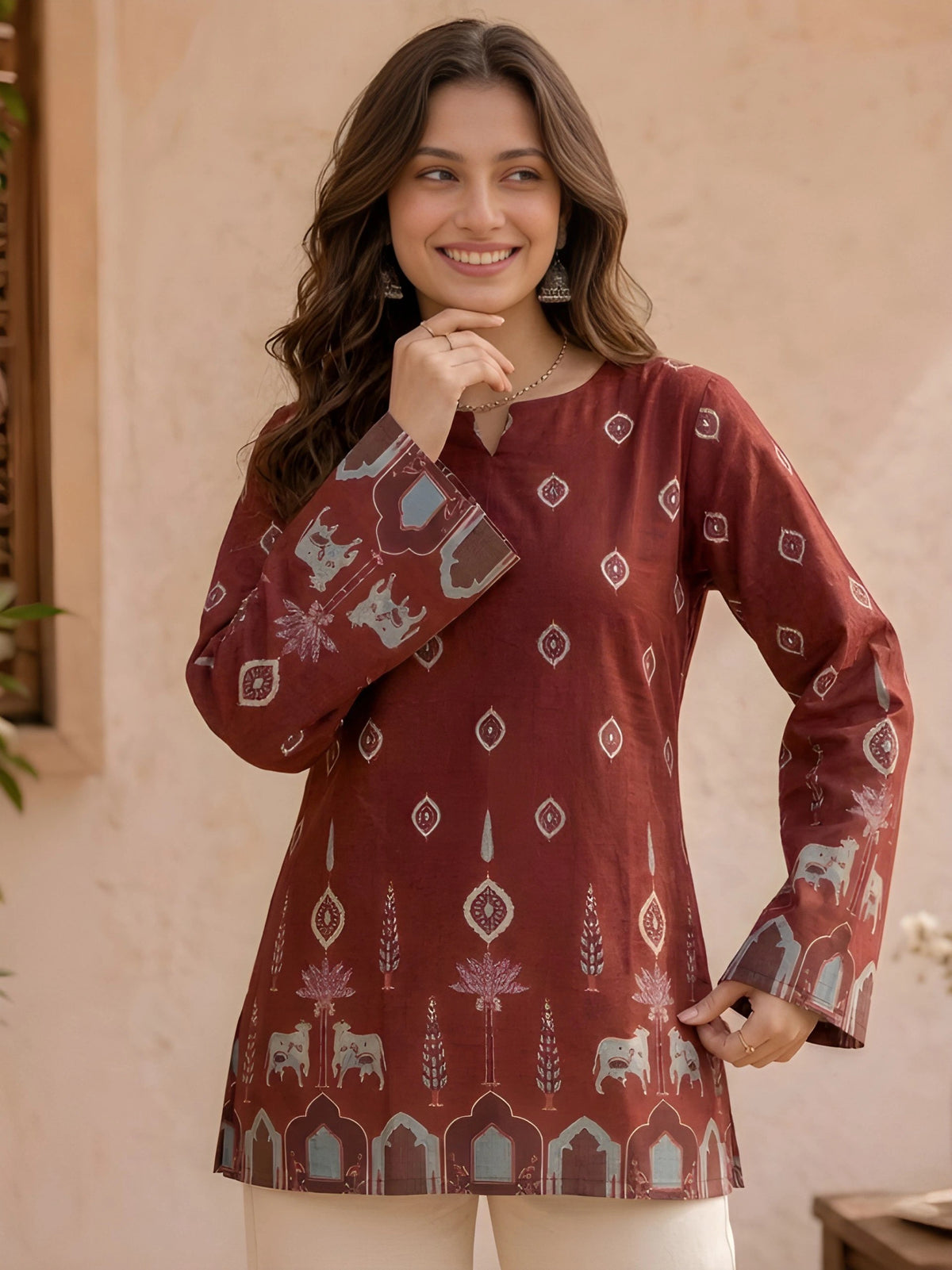 Woman wearing a patterned maroon top with a beige background