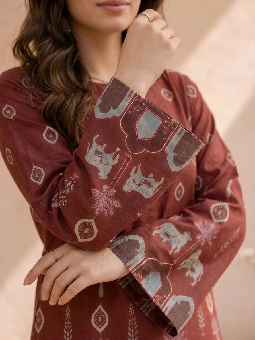 Person wearing a red patterned dress with a neutral background